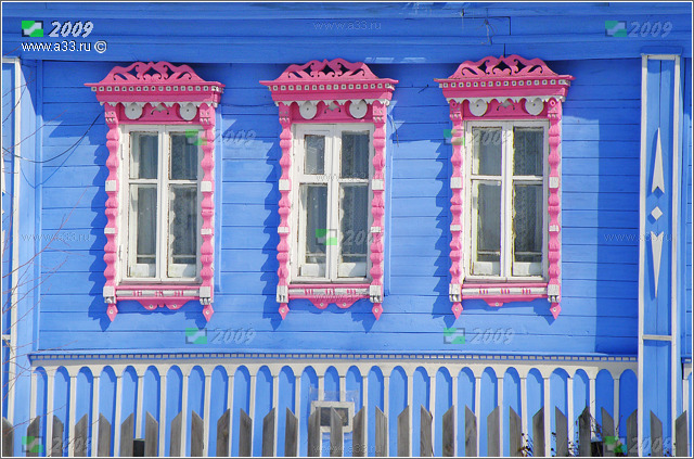 Розовые с белым деревянные наличники на голубом фоне фасада дома в деревне Фомино Гусь-Хрустального района Владимирской области