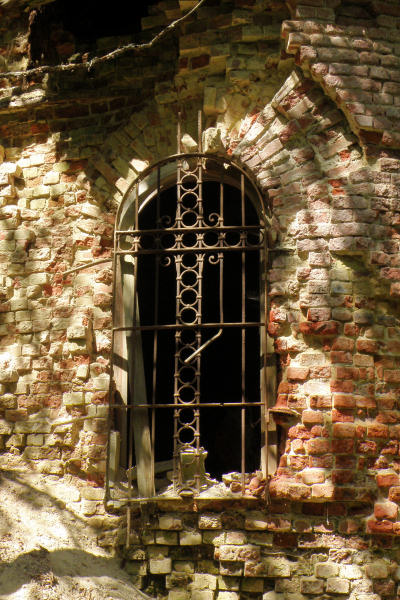 решётка окна с опадающими вокруг кирпичами на церкви Пантелеимона в Кашино Киржачского района Владимирской области 2010