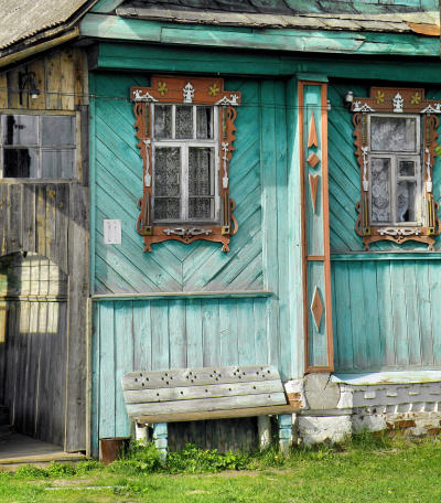 Угол дома 11 с деревянным наличником окна и деревянной скамеечкой в деревне Копцево Вязниковского района Владимирской области