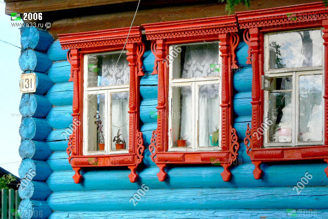 Красные деревянные наличники на крашеном голубом фасаде избы 131 по улице Советской в посёлке Лукново Вязниковского района Владимирской области